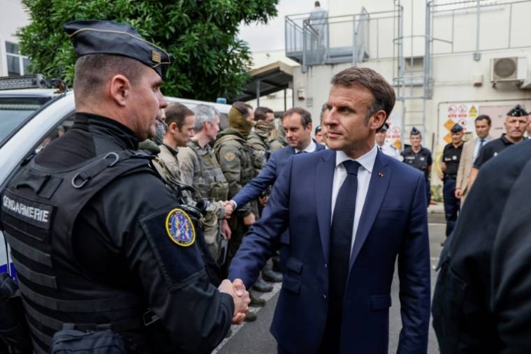 Le président Emmanuel Macron serre la main d'un gendarme le 23 mai 2024 à Nouméa  ( POOL / Ludovic MARIN )