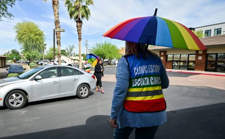 Des personnels chargés d'escorter et d'accueillir les patientes voulant se faire avorter, à l'extérieur de la clinique Camelback Family Planning à Phoenix en Arizona, le 18 avril 2024 ( AFP / Frederic J. BROWN )