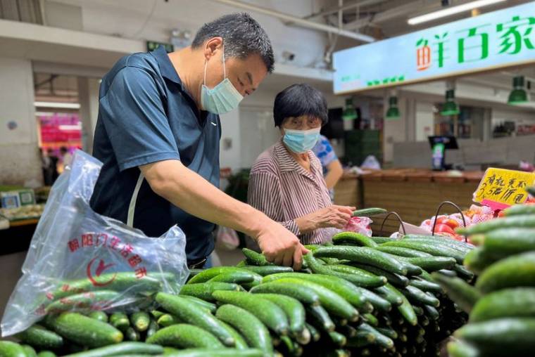 Photo d'archives des clients qui achètent des légumes dans un marché à Pékin