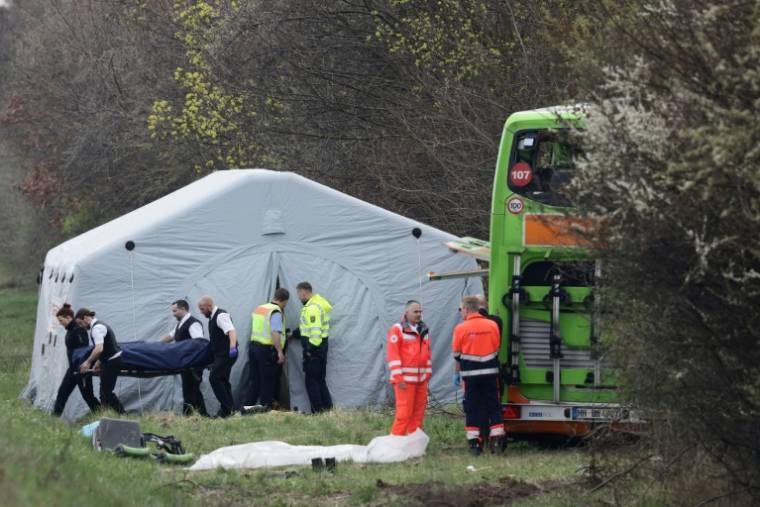 Des employés des pompes funèbres transportent le corps d'une victime après l'accident d'un car de voyageurs sur l'autoroute près de Leipzig (est de l'Allemagne), le 27 mars 2024 ( AFP / Jens Schlueter )