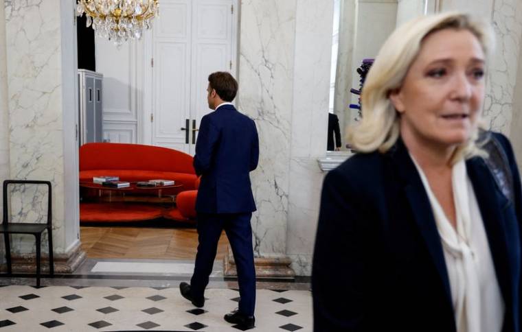 Marine Le Pen s'éloigne après avoir été escortée par le président français Emmanuel Macron après des entretiens à l'Elysée