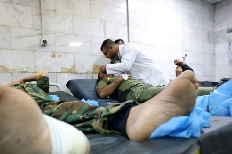Des soldats, blessés dans une explosion nocturne sur une base militaire en Irak, sont soignés aux urgences d'un hôpital de Hilla, le 20 avril 2024 ( AFP / Karar Jabbar )