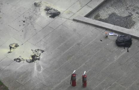 Des extincteurs et un sac à dos sur le sol du square en face du tribunal de New York où un homme a tenté de s'immoler par le feu, 19 avril 2024 ( AFP / ANGELA WEISS )