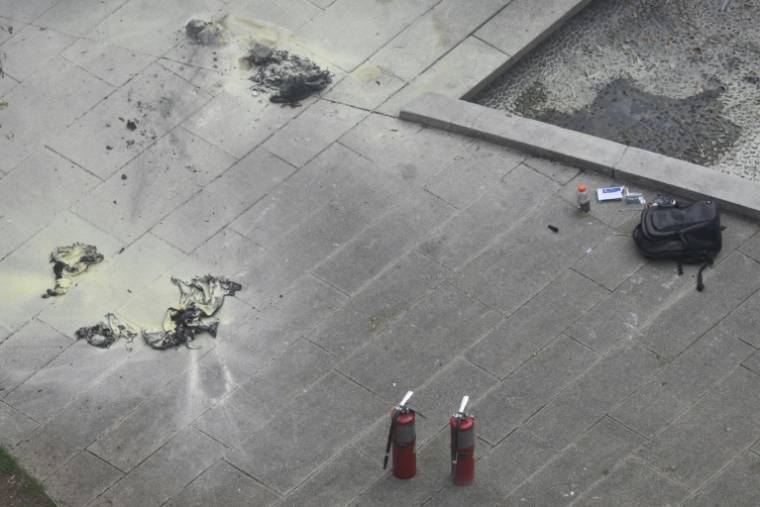 Des extincteurs et un sac à dos sur le sol, en face du tribunal de Manhattan où un homme a tenté de s'immoler par le feu, 19 avril 2024 à New York ( AFP / ANGELA WEISS )