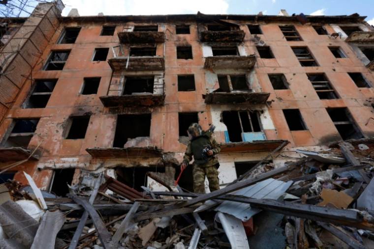 Un sapeur russe inspecte les décombres d'un bâtiment en ruine à Marioupol, le 19 avril 2024 en Ukraine sous contrôle russe ( AFP / - )