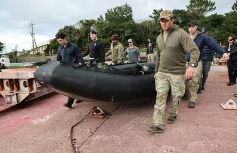 Des personnels militaires américains transportent un canot pour participer aux recherches en mer de l'épave d'un Osprey, sur l'île de Yakushima au Japon le 1er décembre 2023 ( JIJI Press / STR )
