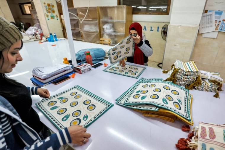 Des femmes préparent des tissus dans un atelier au sud-ouest du Caire, le 23 février 2023 ( AFP / Khaled DESOUKI )