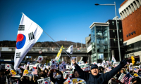 People wave US and South Korean flags at a rally to support impeached South Korea President Yoon Suk Yeol ( AFP / Philip FONG )