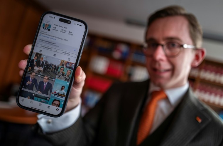 Le député allemand chrétien démocrate Philipp Amthor montre son compte Instagram sur son téléphone, le 10 février 2025 à Berlin ( AFP / John MACDOUGALL )