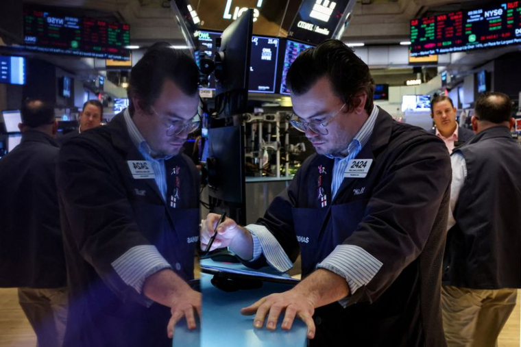 FILE PHOTO: Traders work on the floor of the NYSE in New York