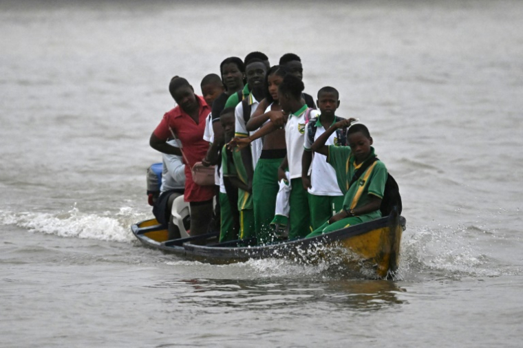 Des étudiants traversent le fleuve Atrato dans un bateau à moteur en bois pour aller étudier dans la municipalité de Quibdo, département de Choco, Colombie, le 30 août 2024 ( AFP / Raul ARBOLEDA )