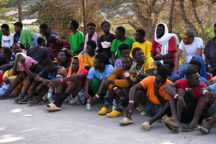 Des migrants attendent devant le centre d'accueil de Lampedusa, le 16 septembre 2023 en Italie ( AFP / Zakaria ABDELKAFI  )
