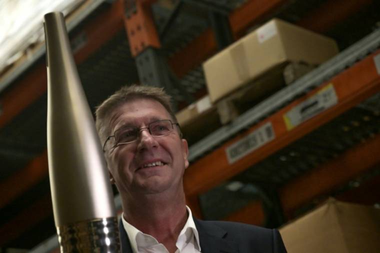 Eric Niedziela, president of the steel group ArcelorMittal brandishing one of the Olympic torches made from recycled steel for the 2024 Olympic and Paralympic Games in Paris, on November 17, 2023 in Vire (Calvados) (AFP / Lou Benoist)
