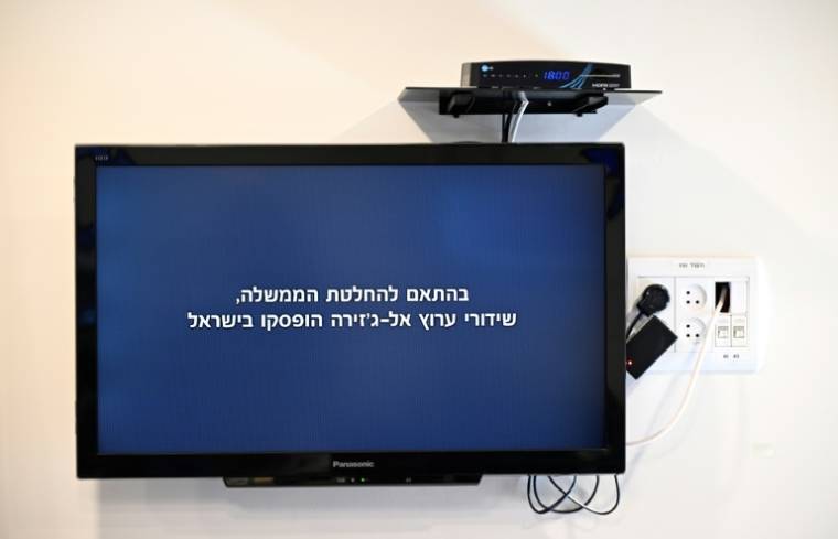 Un écran montre le message diffusé par la chaîne qatarie Al-Jazeera: "Conformément à la décision du gouvernement, les diffusions de la chaîne Al Jazeera ont été suspendues en Israël", le 5 mai à Jérusalem ( AFP / RONALDO SCHEMIDT )