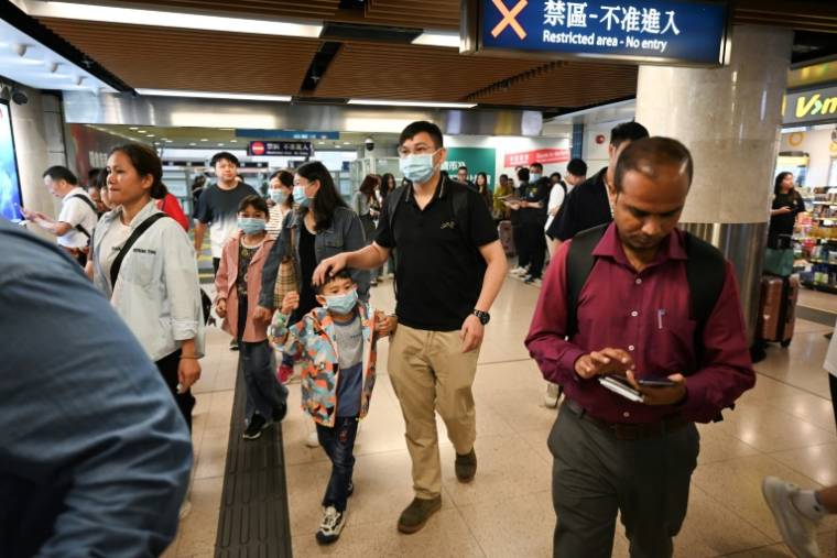 Des touristes de Chine continentale arrivent à Hong Kong par le poste de contrôle frontalier de Lo Wu, le 1er mai 202 ( AFP / Peter PARKS )