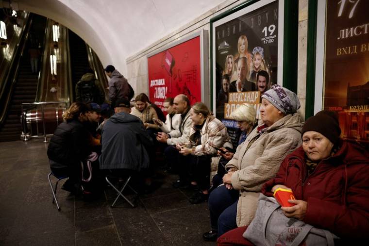 Des personnes s'assoient dans une station de métro pour s'abriter d'un raid aérien à Kiev.