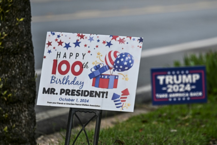 Un panneau célébrant l'anniversaire de Jimmy Carter à côté d'un autre appelant à voter pour Donald Trump, à Plains, en Géorgie, le 30 septembre 2024 ( AFP / CHANDAN KHANNA )