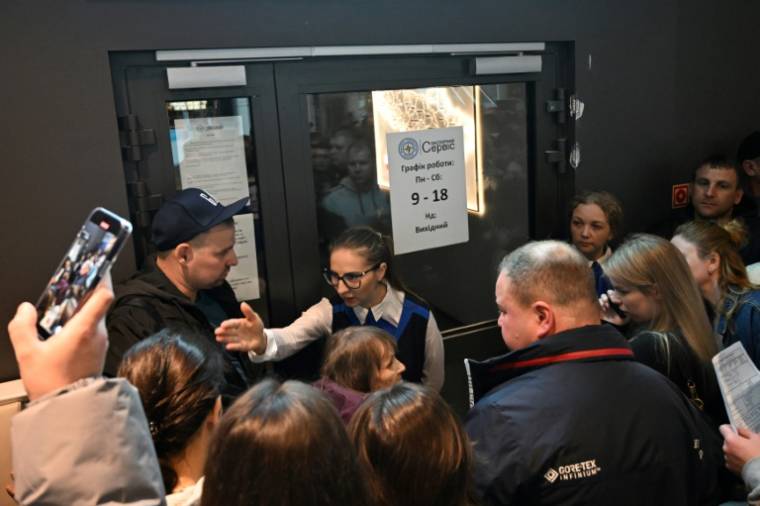 Une employée (C) d'un bureau de délivrance de passeports ukrainiens fermé à Varsovie, le 24 avril 2024 ( AFP / Sergei GAPON )