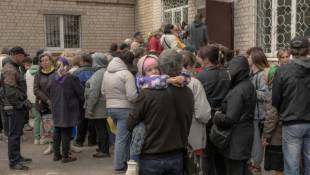 Des habitants qui ont fui différentes zones de la région de Kharkiv, attendent d'être enregistrés à un point d'évacuation, le 14 mai 2024 à Kharkiv, dans le nord-est de l'Ukraine ( AFP / Roman PILIPEY )