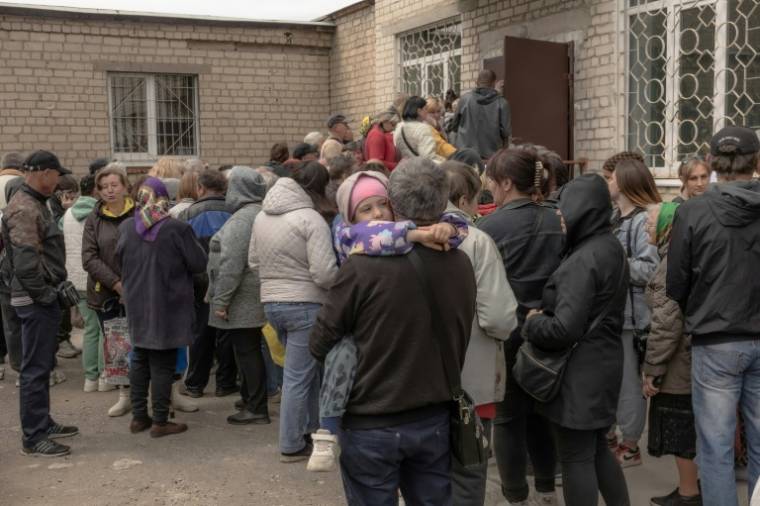 Des habitants qui ont fui différentes zones de la région de Kharkiv, attendent d'être enregistrés à un point d'évacuation, le 14 mai 2024 à Kharkiv, dans le nord-est de l'Ukraine ( AFP / Roman PILIPEY )
