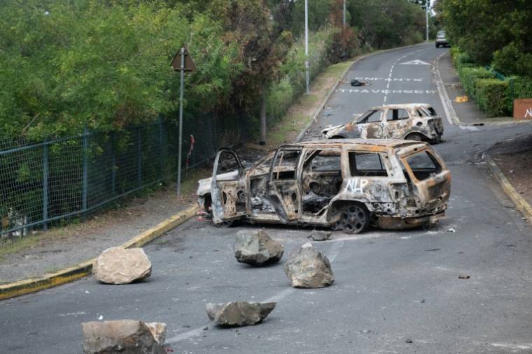 Des voitures incendiées dans le quartier de Magenta, à Nouméa, le 21 mai 2024 en Nouvelle-Calédonie ( AFP / Delphine Mayeur )