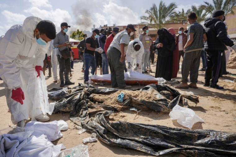 Des travailleurs médicaux palestiniens exhument des corps retrouvés dans la cour d'un hôpital de Gaza, le 21 avril 2024 ( AFP / - )