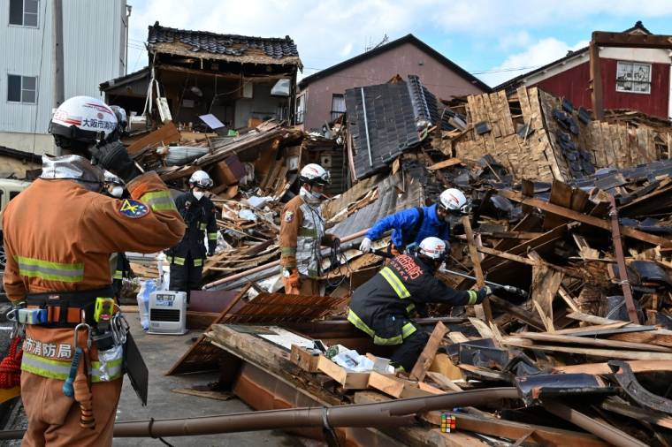 Des secouristes fouilles les décombres d'habitations après un tremblement de terre à Wajima, au Japon, le 4 janvier 2024. ( AFP / KAZUHIRO NOGI )
