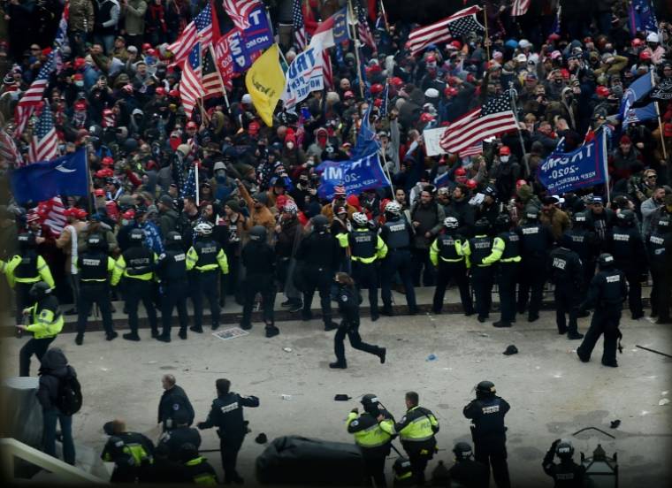 Des policiers face à des partisans de Trump le 6 janvier 2021 ( AFP / Olivier DOULIERY )