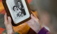 Jeanne Tournellec regarde la photo de mariage de sa sœur Catherine Tournellec, violée par un soldat américain, et de son beau-frère Jean Salaun, chez elle à Locmaria-Plouzane, le 14 mars 2024 dans  le Finistère ( AFP / Fred TANNEAU )