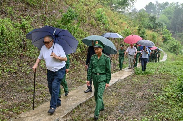 Les vétérans français William Schilardi (g) et Jean-yves Guinrad (d), aidés par des soldats vietnamiens, visitent la colline Him Lam (colline Béatrice), le 6 mai 202 4 à Dien Bien Phu ( AFP / Nhac NGUYEN )