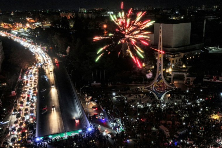 Vue aérienne de feux d'artifice et de la foule de Syriens célébrant le renversement du président Bachar al-Assad, sur la place des Omeyyades à Damas, le 13 décembre 2024 ( AFP / Omar HAJ KADOUR )