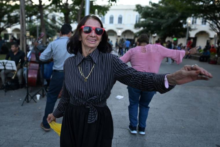 Des personnes dansent au son d'un groupe de musique sur une place du centre historique de San Salvador, le 1er février 2024 ( AFP / Marvin RECINOS )