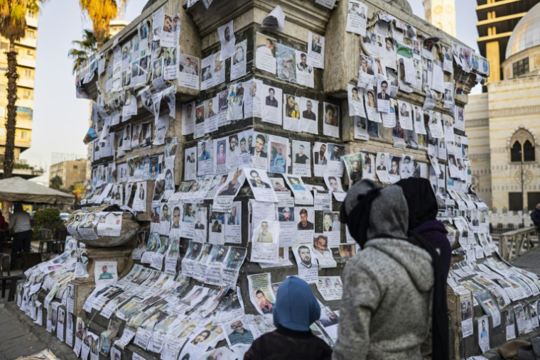 Des photos de personnes disparues collées sur un monument à Damas, le 26 décembre 2024. ( AFP / Sameer Al-DOUMY )