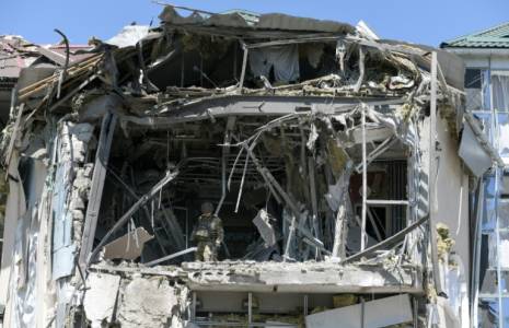 Des enquêteurs militaires sur les lieux d'une frappe ukrainienne sur un bâtiment abritant un restaurant à Donetsk, en Ukraine contrôlée par la Russie, le 11 mai 2024 ( AFP / STRINGER )