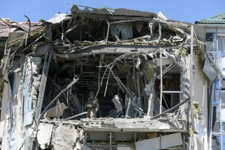 Des enquêteurs militaires sur les lieux d'une frappe ukrainienne sur un bâtiment abritant un restaurant à Donetsk, en Ukraine contrôlée par la Russie, le 11 mai 2024 ( AFP / STRINGER )