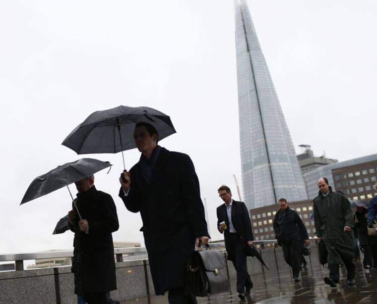 Des employés s'abritant de la pluie à Londres