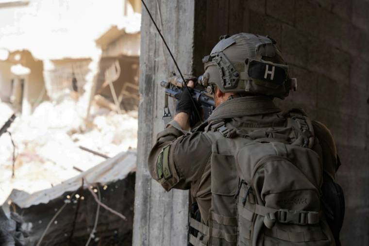 Cette photo diffusée par l'armée israélienne le 12 juillet 2024 montre un soldat israélien pointant son fusil depuis un bâtiment dans la bande de Gaza ( Israeli Army / - )