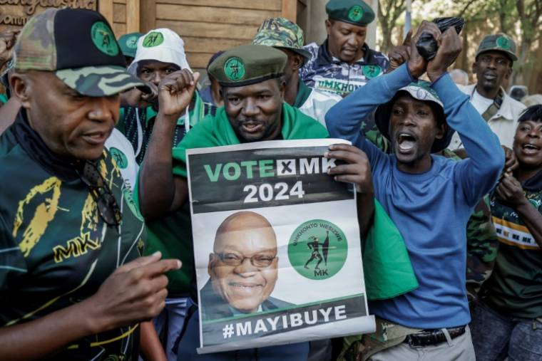 Un partisan de l'ex-président sud-africain Jacob Zuma tient une pancarte à son effigie devant la Cour constitutionnelle, à Johannesburg, le 20 mai 2024 ( AFP / Marco Longari )