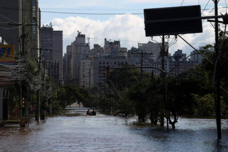 Des pompiers en bateau dans la ville inondée de Porto Alegre, dans l'Etat du Rio Grande do Sul, le 9 mai 2024 au Brésil ( AFP / Anselmo CUNHA )