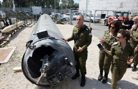 Le porte-parole de l'armée israélienne, le contre-amiral Daniel Hagari (C), et d'autres militaires se tiennent à côté d'un missile balistique iranien tombé en Israël, lors d'une tournée à la base de Julis dans le sud d'Israël, le 16 avril 2024 ( AFP / GIL COHEN-MAGEN )