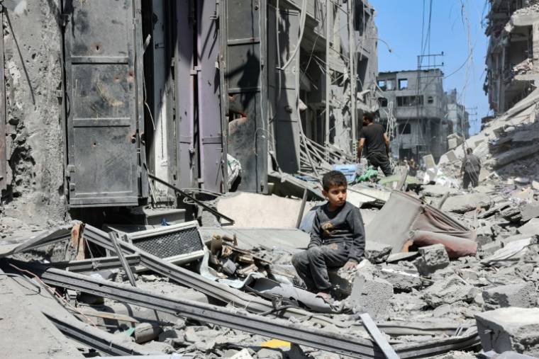 Un enfant au milieu des débris d'un bâtiment détruit par un bombardement israélien dans le quartier de Zeitoun, dans le centre de la bande de Gaza, le 15 mai 2024 ( AFP / - )