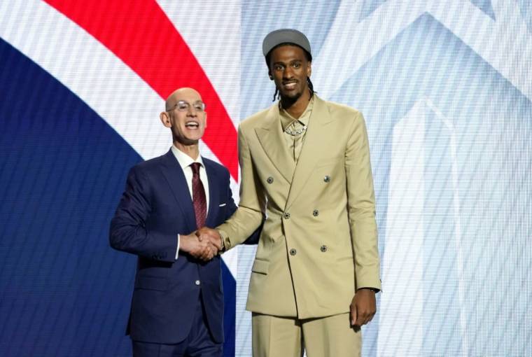 Le président de la NBA Adam Silver et le joueur français Alex Sarr (d) sélectionné en deuxième position de la Draft NBA ,le 26 juin 2024 à New York ( AFP / TIMOTHY A. CLARY )