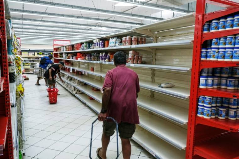 Des habitants font des courses dans des rayons partiellement vides dans le quartier Magenta à Nouméa en Nouvelle-Calédonie, le 18 mai 2024 ( AFP / Theo Rouby )