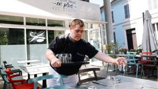 Tristan, employé au restaurant "Un petit truc en plus", prépare les tables pour les clients, le 13 juin 2024 à Mulhouse, dans le Haut-Rhin ( AFP / Abdesslam MIRDASS )