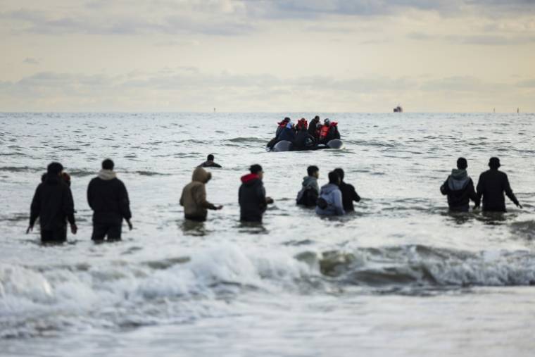 Des migrants candidats à la traversée de la Manche cherchent à rejoindre une embarcation le 26 avril 2024 à Loon-Plage, dans le Nord ( AFP / Sameer Al-DOUMY )