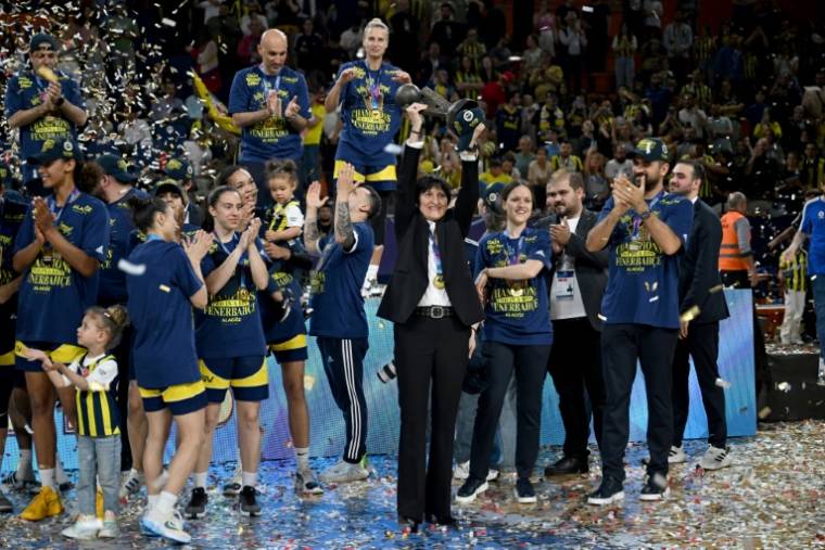 Valérie Garnier (au centre), coach de Fenerbahçe et ex-sélectionneuse de l'équipe de France de basket, brandit le trophée de l'Euroligue féminine après la victoire du club turc face à Villeneuve d'Ascq, le 14 avril 2024 à Mersin ( AFP / OZAN KOSE )