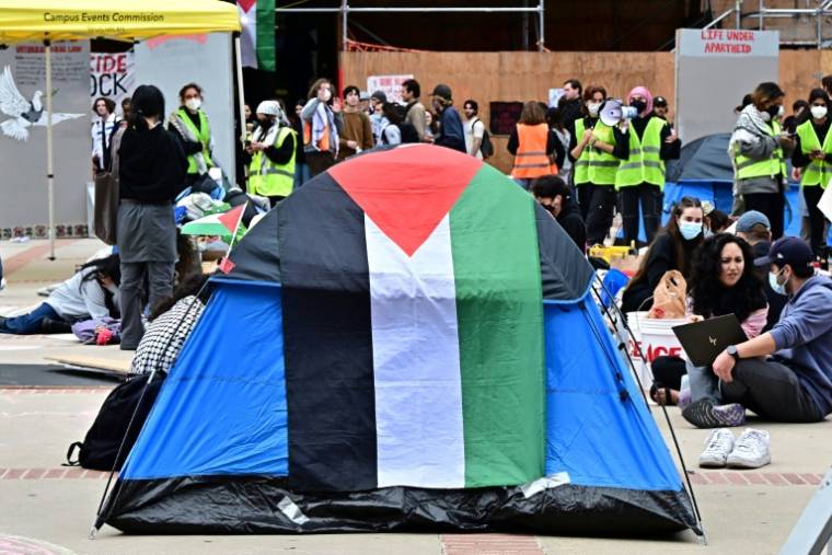 Des étudiants et des militants pro-palestiniens se rassemblent dans un campement, près d'une tente affichant un drapeau palestinien, lors d'une manifestation à l'Université de Californie à Los Angeles (UCLA), le 25 avril 2024 ( AFP / Frederic J. BROWN )