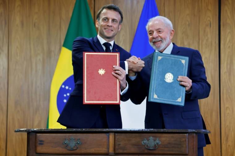 Le président brésilien Luiz Inacio Lula da Silva (d) et son homologue français Emmanuel Macron lors de la signature d'accords bilatéraux, le 28 mars 2024 à Brasilia ( POOL / Ludovic MARIN )