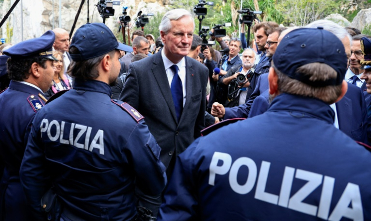 Le Premier ministre français Michel Barnier (c) arrive à la frontière  franco-italienne pour une visite consacrée à l'immigration, le 18 octobre 2024 à Grimaldi ( AFP / Valery HACHE )