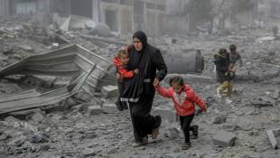 Une femme et ses enfants fuient au milieu des décombres le centre de la ville de Gaza après un bombardement israélien, le 18 mars 2024 ( AFP / - )